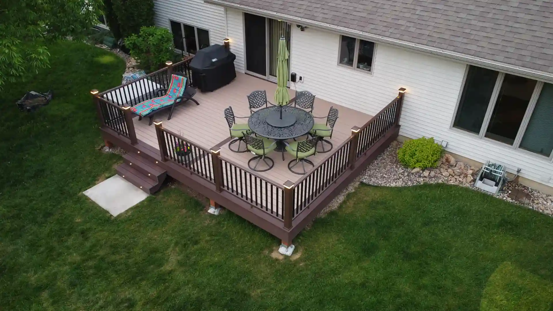 photo of a raised deck with deck railing, deck steps, and in-step lighting - custom decks contractor near me in Dane County